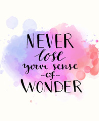 Fototapeta na wymiar Never lose your sense of wonder. Black inspirational quote on purple watercolor imitation background, brush typography for poster, t-shirt or card. Vector calligraphy art