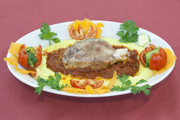 pork shank on a bed of polenta amatriciana