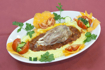 pork shank on a bed of polenta amatriciana