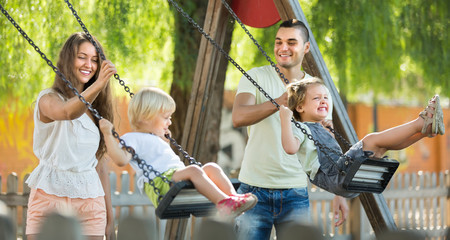 Parents with kids at swings