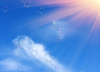 bubbles in the blue sky against a background of rays