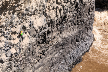 Young Brave Man Climbing Natural Rock Wall