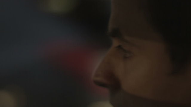 Closeup of tired man driving car at night. Dangerous maniac looking for victim