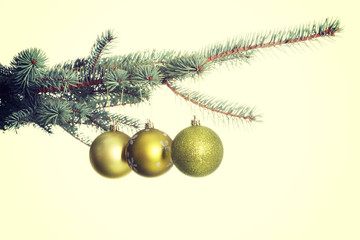 Three christmas balls hanging on a twig.