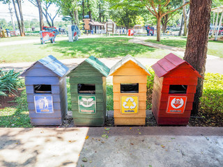 Old wooden bins , blue, green , yellow, red , marked with recycl