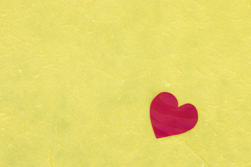 Red heart on yellow paper background, love concept