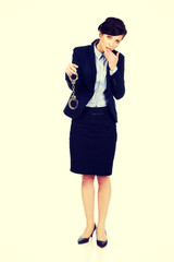 Businesswoman holding metal handcuffs.