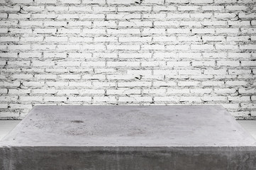 Empty concrete desk on grunge brick wall background with space for text or image