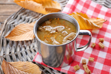 Mug of soup on wicker mat closeup