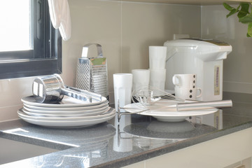 Fototapeta na wymiar White ceramic set and stainless kitchen utensils on the counter