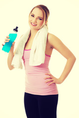 Naklejka premium Woman in fitness clothes drinking isotonic drink.