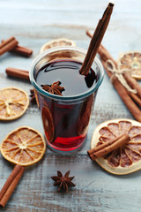 Tasty mulled wine and spices, on blue wooden background, close-up