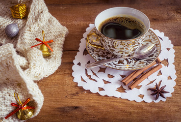 Photo of glowing white and golden cup with tasty coffee, Christmastime table setting, tea mug on brown wooden background, snowflake decoration, New Year ornament, Christmas home decor with warm scarf 