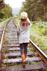 Young woman walking on rail of railway tracks