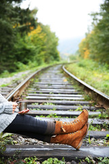 Young woman sitting on rail track