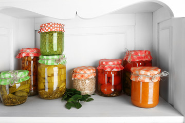 Jars with pickled vegetables on shelf