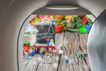 image of plane window and Christmas ornaments on wood background