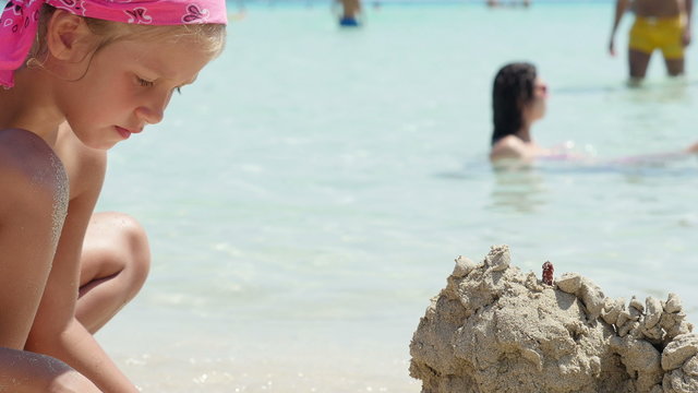 Child playing sand on the beach. 4K UHD.
