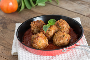 Meatball with tomato sauce in pan.