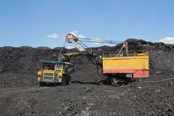 Coal mining. The dredge loads the truck coal.