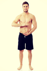 Fototapeta premium Sexy muscular man holding copyspace in hands.