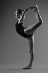 Modern ballet dancer posing on dark background