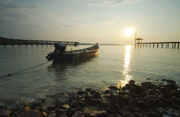 silhouette of fisherman boat left alone before sunset