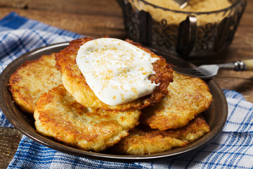 Homemade potato pancakes served with sour cream and brown sugar