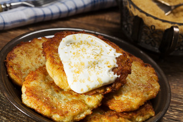 Homemade potato pancakes served with sour cream and brown sugar