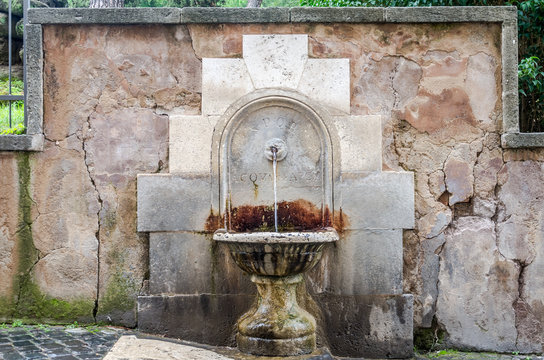 Ancient drinking fountain historic fountain from which water pours out of stone and concrete on Capitol Square in Rome, capital of Italy