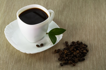 Black coffee in white cup and coffee beans