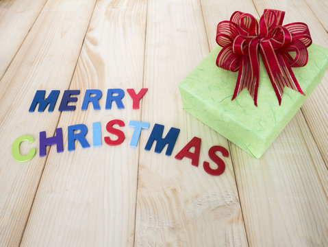 Gift box 2 - One green gift box and red bow with wooden font on wood background (Christmas Holiday)