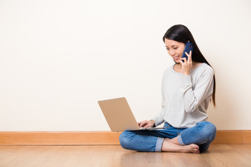 Woman talk to someone by mobile phone with watch on the laptop c