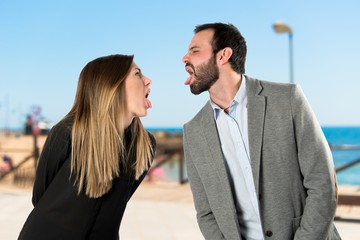 Couple sticking out her tongue over white background