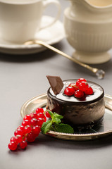Chocolate cake with a red currant on a dish