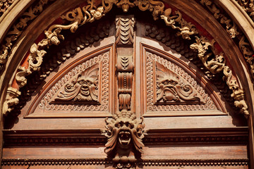 Obraz premium Decorative molding and carved wood with faces on the facade of house