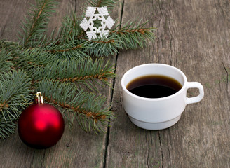 still life a fir-tree branch with brightly red ornament and a cu
