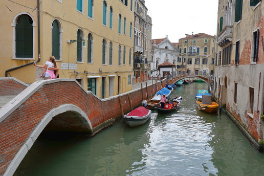Tourists are photographed on a bridge in Venice, Italy
