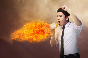 Business man holding megaphone in fire and shouting