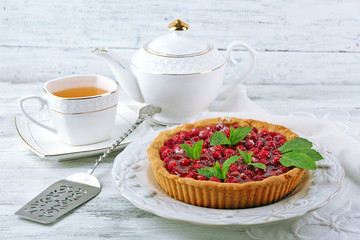 Tart with raspberries and tasty tea, on color  wooden background