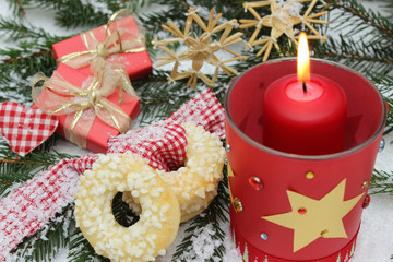 Weihnachtsdekoration mit roter Kerze und Weihnachtskringel  