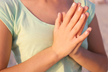 Young beautiful woman meditating yoga on the beach, back view, close up
