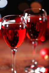 Wine glasses with Christmas decorations on wooden table, close up