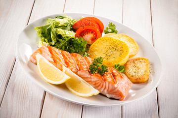 Fried salmon and vegetables on white background