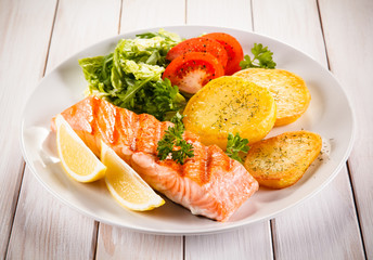 Fried salmon and vegetables on white background