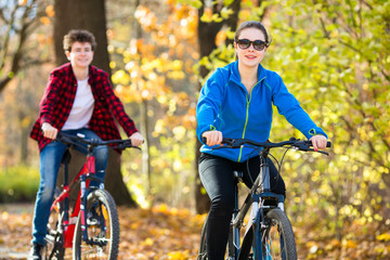 Fototapeta na wymiar Urban biking - teens riding bikes in city park 