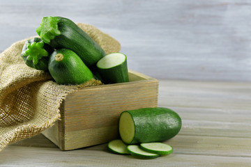 Fresh zucchini in box on wooden background