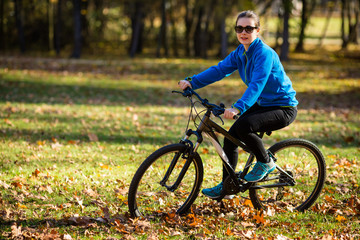 Fototapeta na wymiar Girl biking in city park