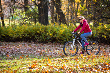 Fototapeta na wymiar Urban biking - woman riding bike in city park 