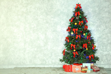 Decorated Christmas tree on light wall background